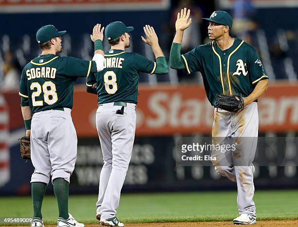 Kyle Blanks of the Oakland Athletics celebrates the win with teammate Jed Lowrie and Eric Sogard after the game against the New York Yankees on June...