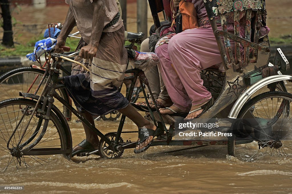 Razarbag Road in Dhaka is submerged by flood water following...