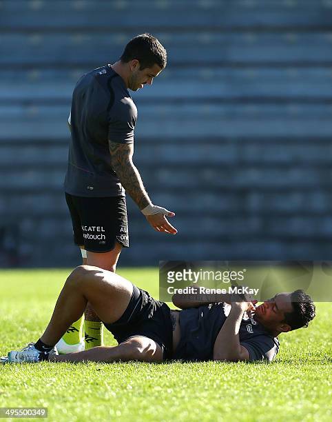Adam Reynolds offers John Sutton a hand up during a South Sydney Rabbitohs NRL training session at Redfern Oval on June 4, 2014 in Sydney, Australia.