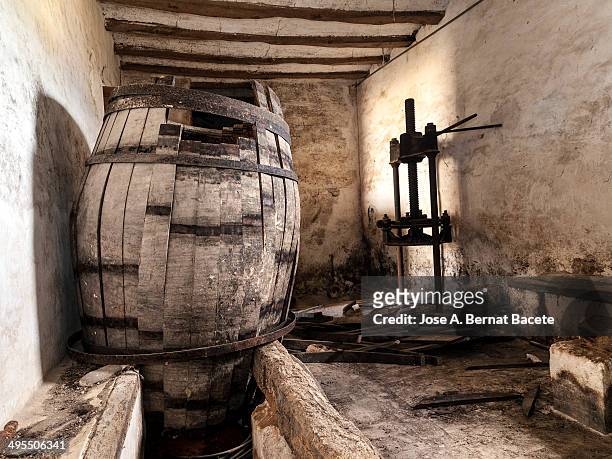 wine cellar with a broken tap and a wine press - wooden wine press stock pictures, royalty-free photos & images
