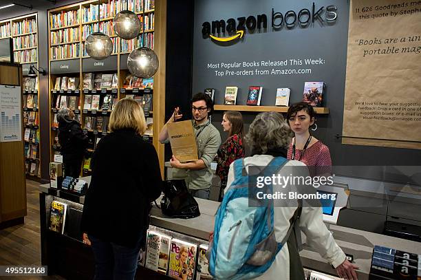 Customers pay for purchases at the Amazon Books store in Seattle, Washington, U.S., on Tuesday, Nov. 3, 2015. Amazon.com Inc.'s store lets shoppers...
