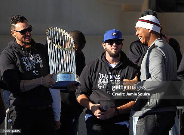 Paulo Orlando, Mike Moustakas and Salvador Perez entertain the crowd with the trophy during a parade and celebration in honor of the Kansas City...