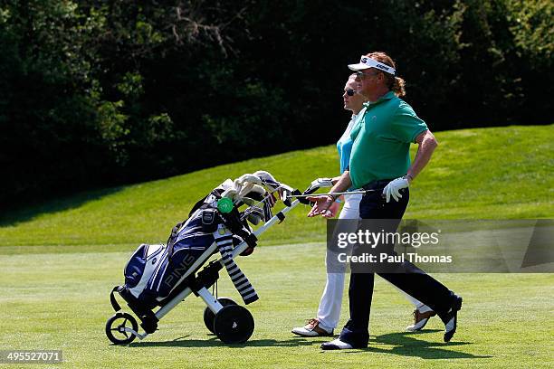 Miguel Angel Jimenez of Spain walks with his wife Susanne Jimenez down a fairway during the Lyoness Open preview day at the Diamond Country Club on...