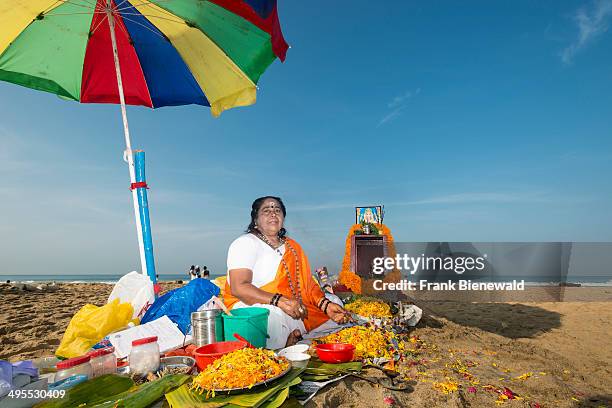 One female priest is offering the Veli Tarpanam Pooja, a farewell ritual for passed away family members, on the beach.