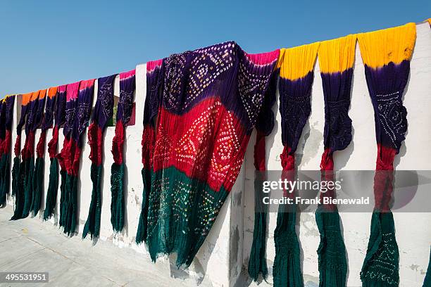 Colorful material for mainly saris and scarves, dyed in traditional technique by hand, is drying in the sun.