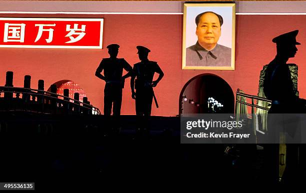 Chinese Paramilitary police officers stand guard below a portrait of the late leader Mao Zedong in front of the Forbidden City at Tiananmen Square on...