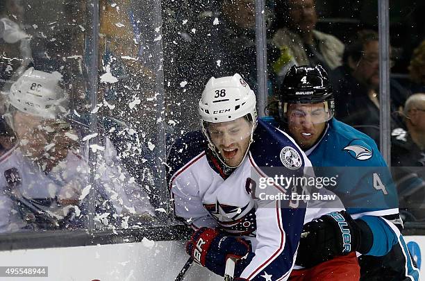 Boone Jenner of the Columbus Blue Jackets and Brenden Dillon of the San Jose Sharks collide as they go for the puck at SAP Center on November 3, 2015...
