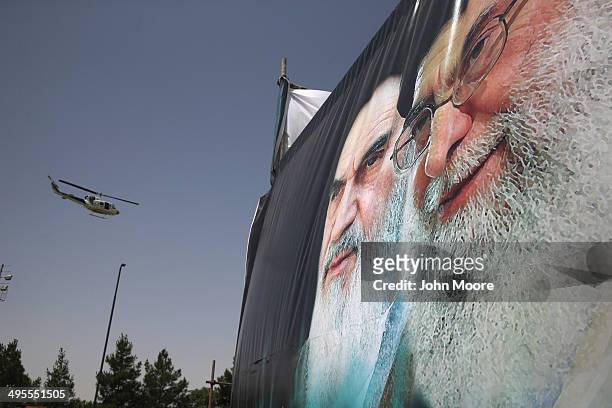 An Iranian police helicopter passes above portraits of Iran's supreme leader Ayatollah Ali Khamenei and the former Ayatollah Khomeini outside...