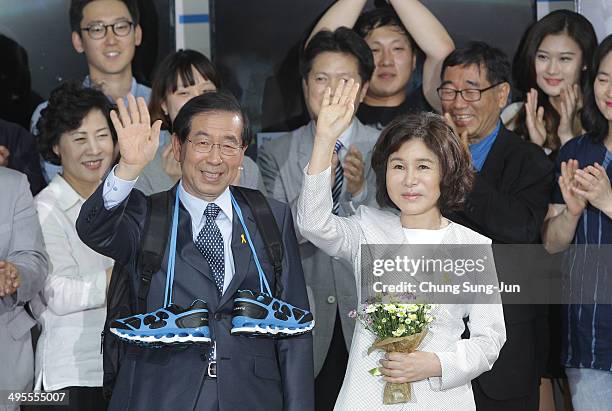 Seoul city mayor-elect Park Won-Soon of the main opposition party New Politics Alliance for Democracy celebrates and his wife Kang Nan-Hee wave to...