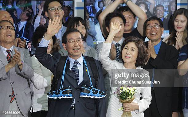 Seoul city mayor-elect Park Won-Soon of the main opposition party New Politics Alliance for Democracy celebrates and his wife Kang Nan-Hee wave to...