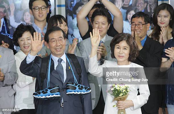 Seoul city mayor-elect Park Won-Soon of the main opposition party New Politics Alliance for Democracy celebrates and his wife Kang Nan-Hee wave to...