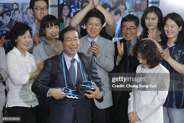 Seoul city mayor-elect Park Won-Soon of the main opposition party New Politics Alliance for Democracy celebrates and his wife Kang Nan-Hee wave to...