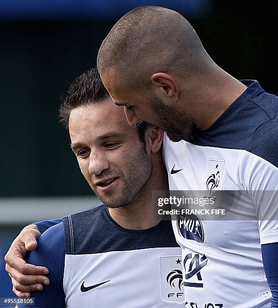 France's midfielder Mathieu Valbuena speaks with France's forward Karim Benzema during a training session in Clairefontaine-en-Yvelines, outside...