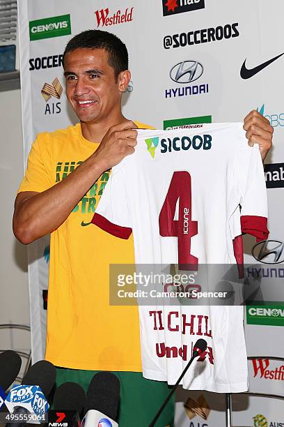 Tim Cahill of the Socceroos is presented with a personalised top from Desportiva Ferroviaria during an Australian Socceroos press conference at Arena...