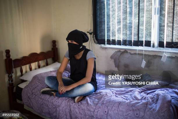 Elizabeth poses sitting on her bed before leaving home to join the Black Bloc group in a protest against the FIFA world Cup at a slum in northern Rio...