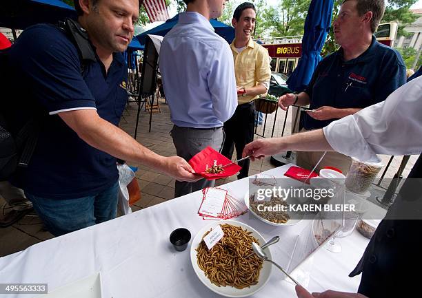 Patron takes a helping of roasted mealworms and roasted crickets on June 4, 2014 during a global Pestaurant event sponsored by Ehrlich Pest Control,...