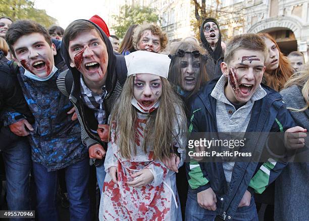 Ukrainians wearing zombie costumes and make-up walk through the streets during the Halloween Parade named "Zombie Walk" in downtown Kiev. More than...