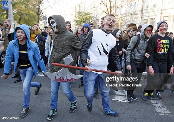 Ukrainians wearing zombie costumes and make-up walk through the streets during the Halloween Parade named "Zombie Walk" in downtown Kiev. More than...