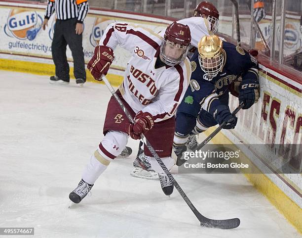 Boston College Eagles' Michael Sit clears the puck with pressure from Norte Dame Fighting Irish David Gerths during second period action of the...