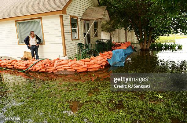 Farr West checks on his sump pump outside his home in Greeley that is flooded by rising water along the Poudre River, June 4, 2014. A flood warning...