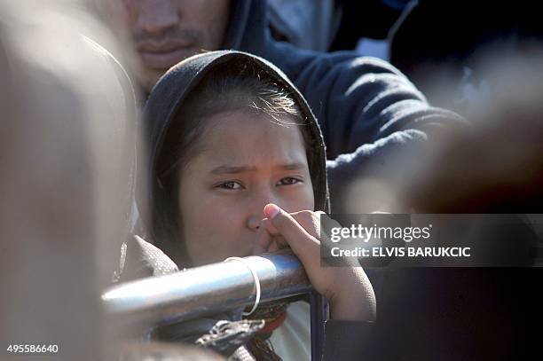 Girl queues with other migrants and refugees to enter a transit camp in Slavonski Brod on November 4, 2015. Thousands of newly arrived migrants and...