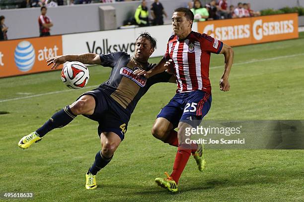 Danny Cruz of Philadelphia Union crosses the ball past Donny Toia of Chivas USA in the first half at StubHub Center on May 31, 2014 in Los Angeles,...