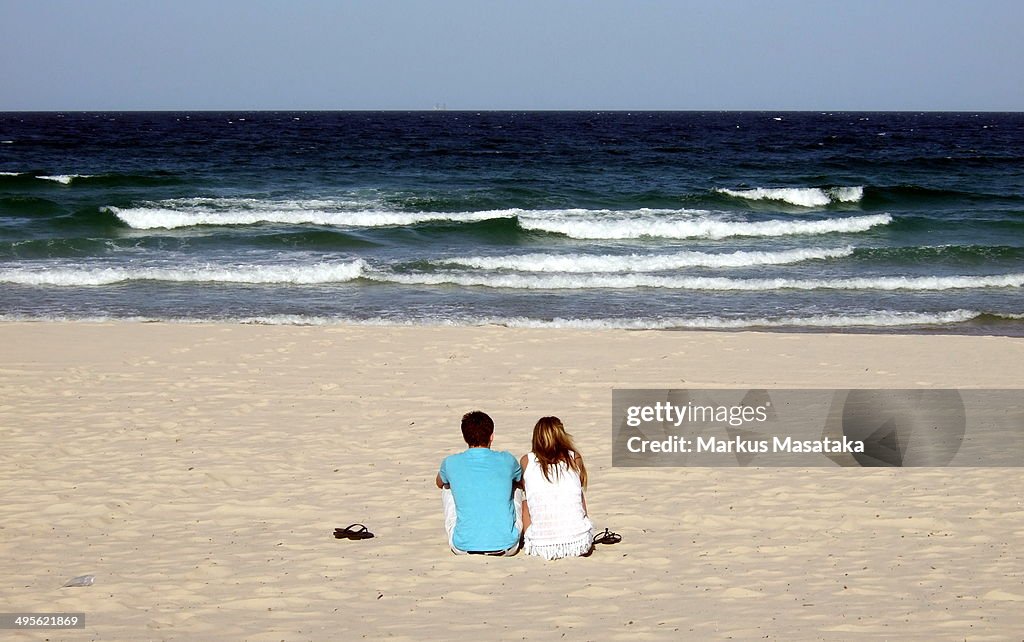 Couple watching big waves on the beach