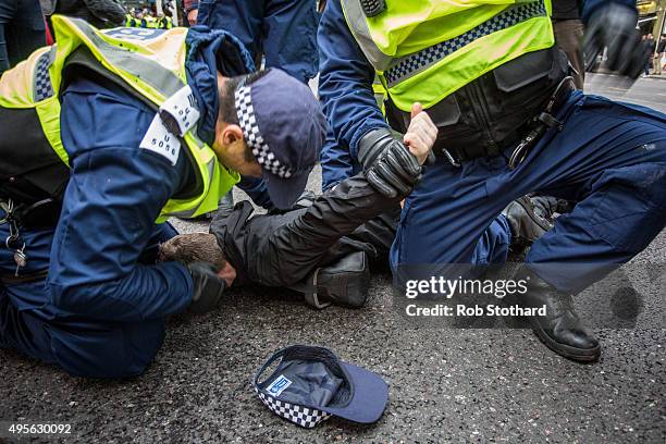 Protester is detained by police during a protest against education cuts and tuition fees near Victoria station on November 4, 2015 in London,...