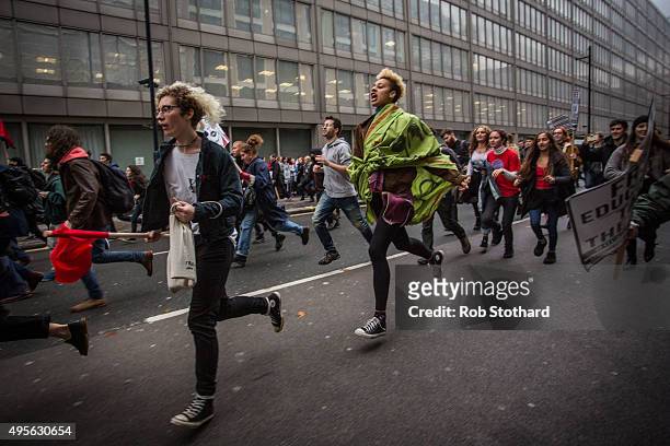 Protestors run along Victoria Street during a protest against education cuts and tuition fees on November 4, 2015 in London, England. University...