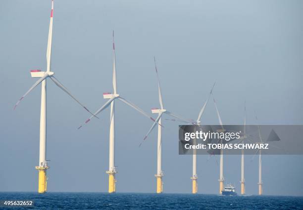 Service vessel passes by wind turbines of the German offshore wind farm "Amrum Bank West" owned by German energy company E.ON near the Heligoland...