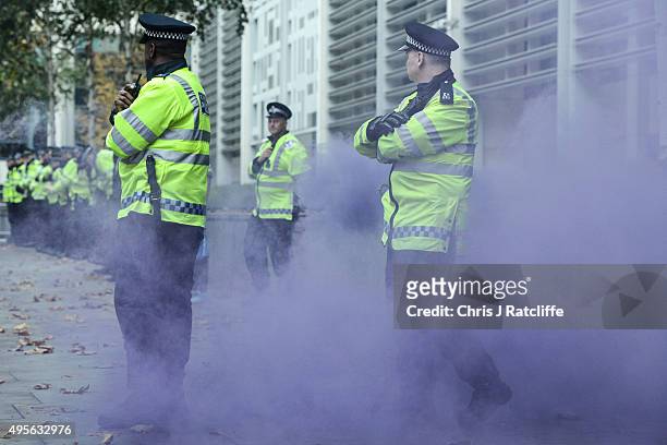 Protesters throw smokes bombs at police during a demonstration against education cuts on November 4, 2015 in London, England. University students...