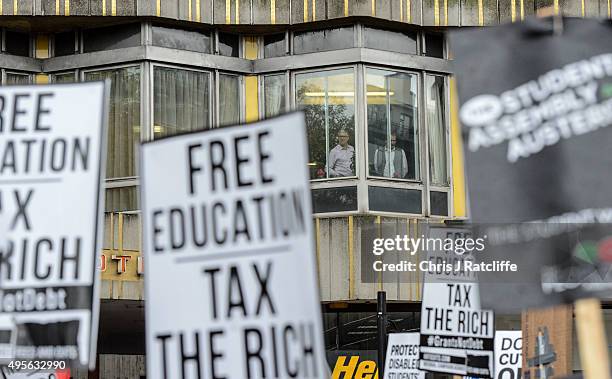 Members of the public look over protesters during a demonstration against education cuts on November 4, 2015 in London, England. University students...