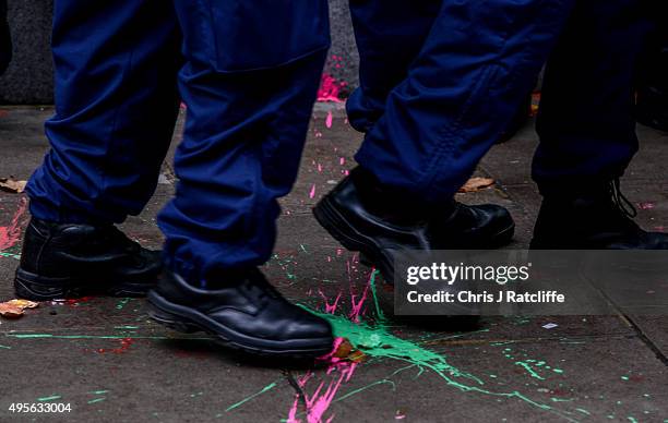 Police step over paint thrown at them during a demonstration against education cuts on November 4, 2015 in London, England. University students from...