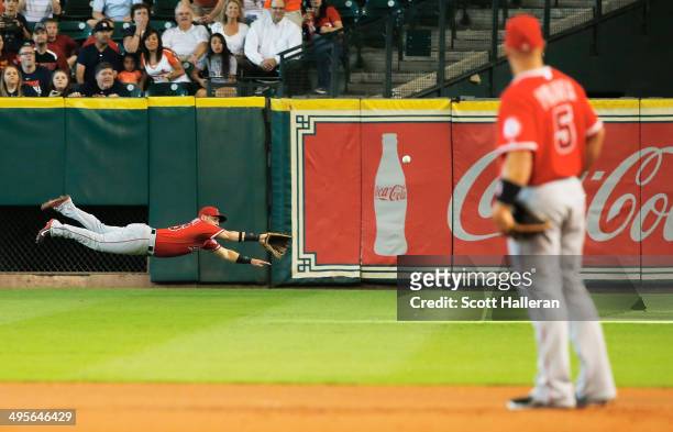 Kole Calhoun of the Los Angeles Angels dives for a ball in right field as Albert Pujols looks on from first base in the first inning of their game...