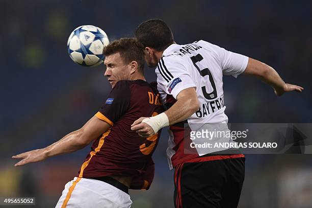 Roma's forward from Bosnia-Herzegovina Edin Dzeko fights for the ball with Leverkusen's Greek defender Kyriakos Papadopoulos during the UEFA...