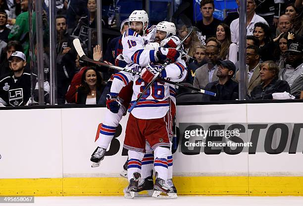Benoit Pouliot of the New York Rangers celebrates with teammate Derick Brassard and Mats Zuccarello after Pouliot scores the first goal in the first...