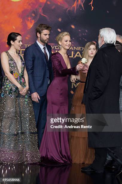 Actress Jennifer Lawrence, wearing a Dior dress, chats with actor Donald Sutherland during the world premiere of the film 'The Hunger Games:...