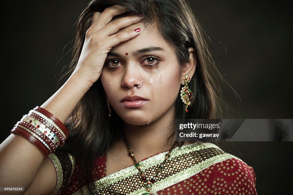 Hindu married woman crying with tears and looking at camera.
