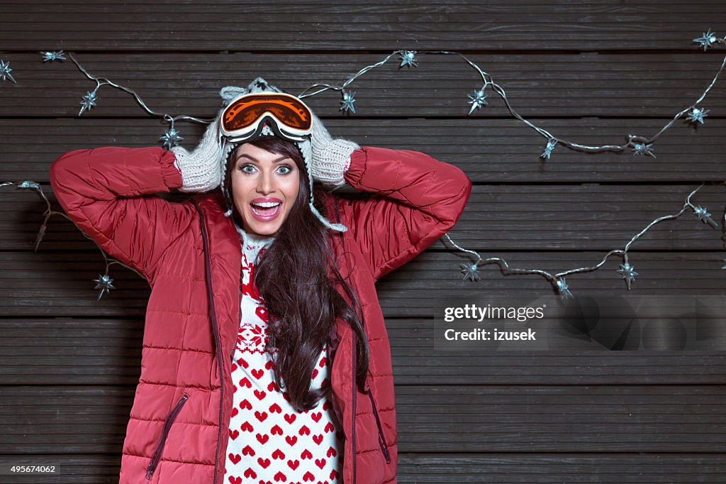Surprised woman in winter outfit, wearing puffer jacket and goggle