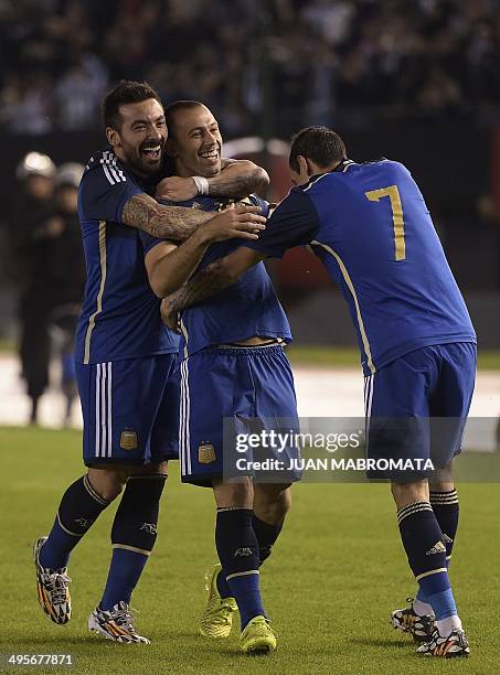 Argentina's midfielder Javier Mascherano celebrates with teammates forward Ezequiel Lavezzi and midfielder Angel Di Maria after scoring the team's...