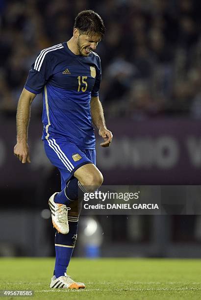 Argentina's defender Martin Demichelis flexes his leg after colliding with an opponent during a friendly match against Trinidad and Tobago at the...