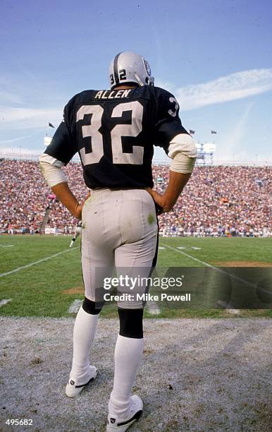 Marcus Allen of the Los Angeles Raiders stands on the sidelines during a game against the Seattle Seahawks at the Los Angeles Coliseum in Los...