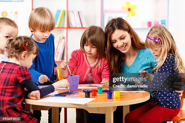 group of elementary age children in art class with teacher - tempera painting stock pictures, royalty-free photos & images