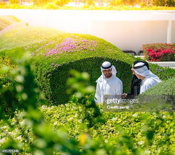 middle eastern people walking in the park - dubai park stock pictures, royalty-free photos & images