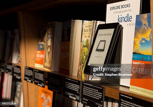 Books are displayed along side an Amazon Kindle device, which offers previews of those same books on nearby shelves at the Amazon Books store on...