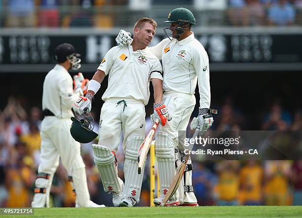 David Warner of Australia is congratulated by Usman Khawaja of Australia after reaching his century during day one of the First Test match between...