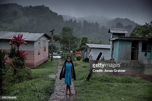 Young woman standing in the rain in the village Naviavia, which has just been bought from Fiji by Kiribati to ensure that Kiribati islanders have a...