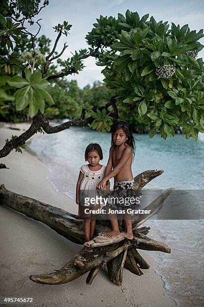 Two young girls standing on the beach at the northernmost part of the Tarawa atoll. The people of Kiribati are under pressure to relocate due to sea...