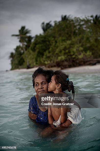 Mother and her daughter taking a dip in the sea. Their land is on the northernmost part of the Tarawa atoll which is slowly being consumed by the...