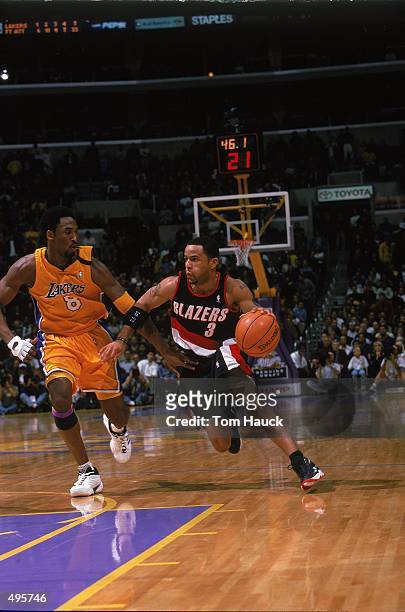 Damon Stoudamire of the Portland TrailBlazers dribbling the ball down court while being gaurded by Kobe Bryant during the game against the Los...